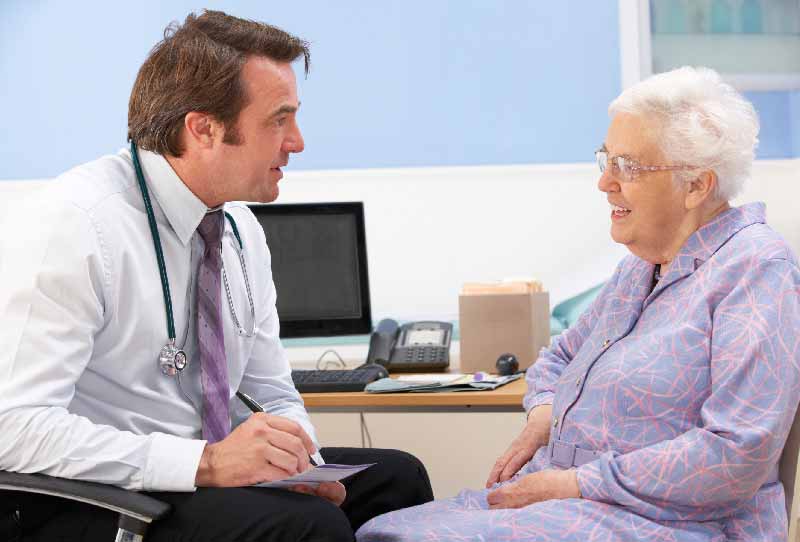 Médico aconselhando paciente idosa